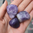 Three lepidolite pocket crystals on a palm