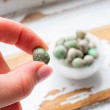 Close-up of a variscite tumbled stone held between fingers