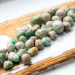 Pile of variscite tumbled stones on a wooden surface